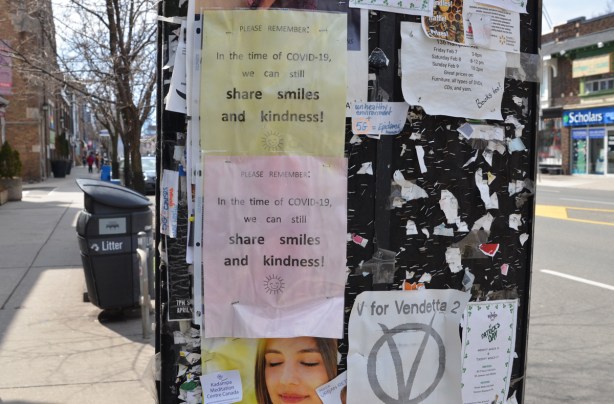 posters on a sidewalk bulletin board, 