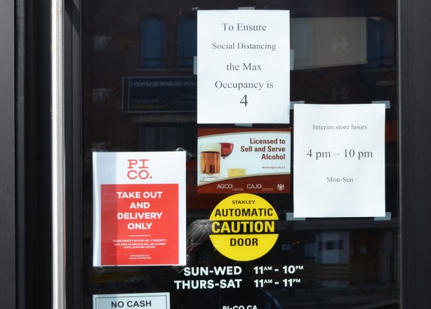 signs and posters on a glass door, entrance to restaurant