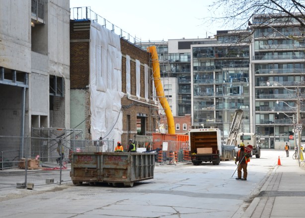 workman with stop sign directing traffic in front of a construction site 