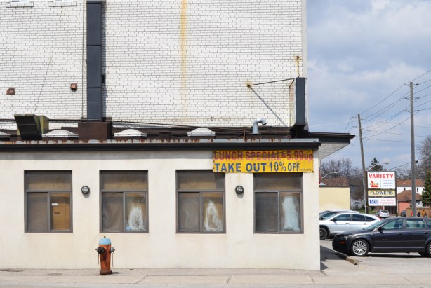 restaurant, white wall, three windows and old sign advertising lunch special 