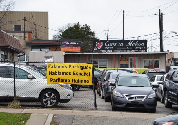 used car lot with trilingual sign, 
