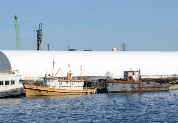 two boats parked in the shipping channel, one is the white and yellow Iroquois
