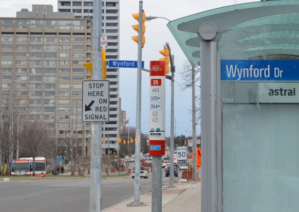 bus stop and shelter on Don Mills Road at Wynford, Crosstown construction and high rises in the background