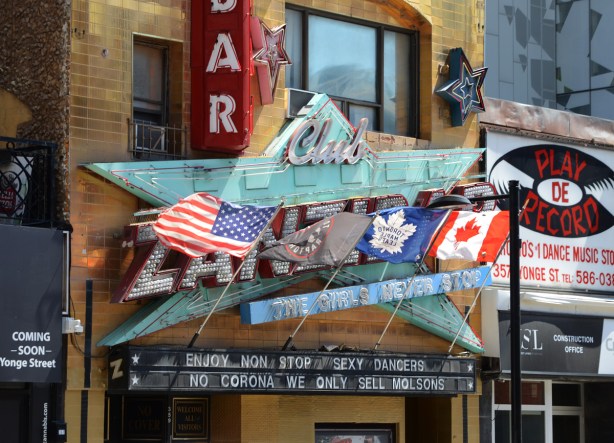 In front of the zanzibar club, sign, with flags and words, that say no corona here we only sell Molsons, 