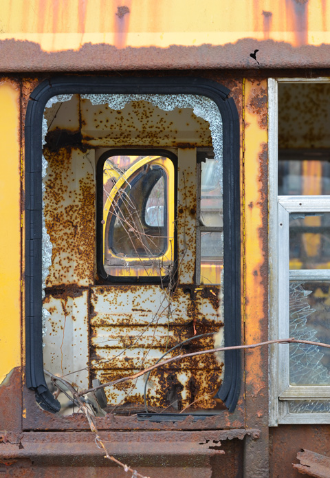 junked, old cars, McLeans Auto Wreckers, looking through broken side windows of a chool bus, back of bus, rusted, yellow,