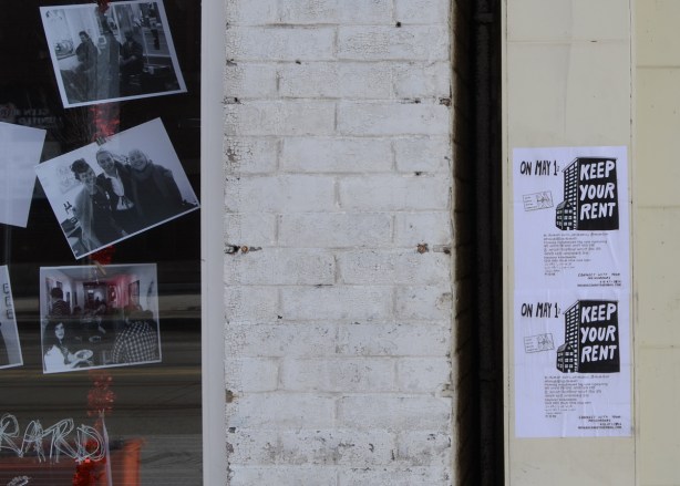 keep your rent May 1 posters beside a gallery with photographs in the window