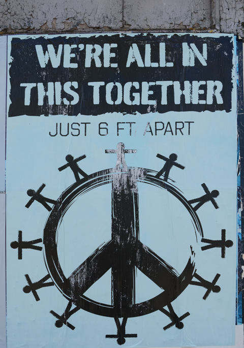 large poster for we're all in this together, peace symbol with stick figures standing around the outside of the circle