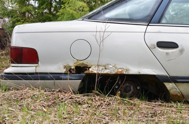 junked, old cars, McLeans Auto Wreckers, back part of white car in ground, no back tire