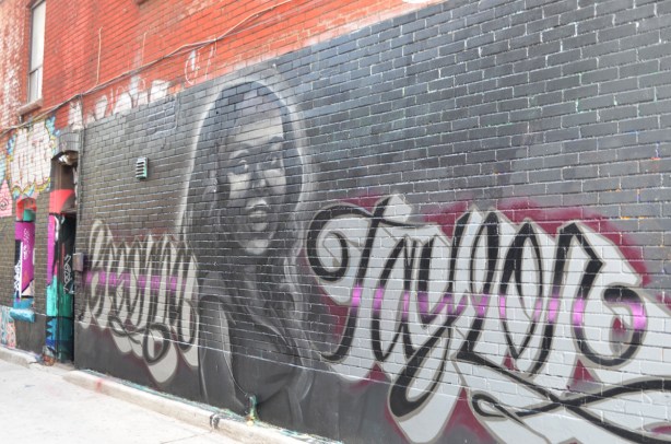a mural featuring a portrait of Breonna Taylor, a black woman who was killed by police in the United States, Her name is written there as well