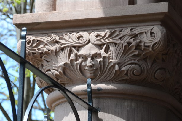 on a stone column, exterior of Queens Park, a face, 