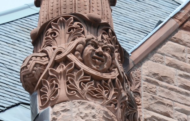 exterior of Queens Park, parliament buildings in Toronto, a laughing face with tongue stuck out, in sandstone 