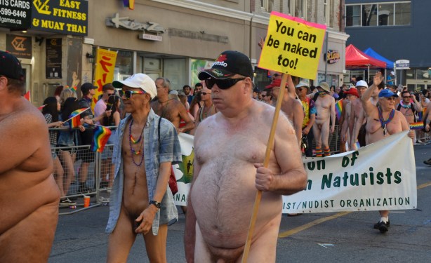 you can be naked too, sign held by nude people walking in pride parade 