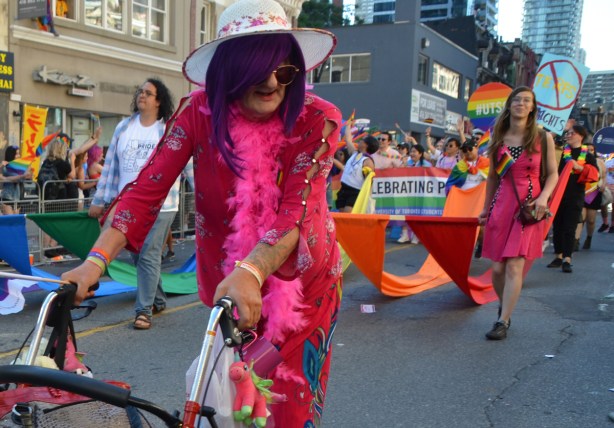 older person walking with walker in pride parade