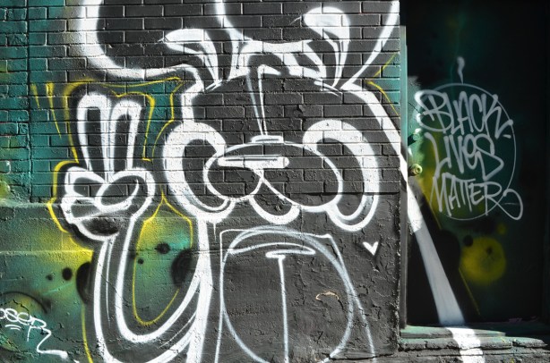 poser bunny mural in graffiti alley, giving peace sign, beside words that say black lives matter
