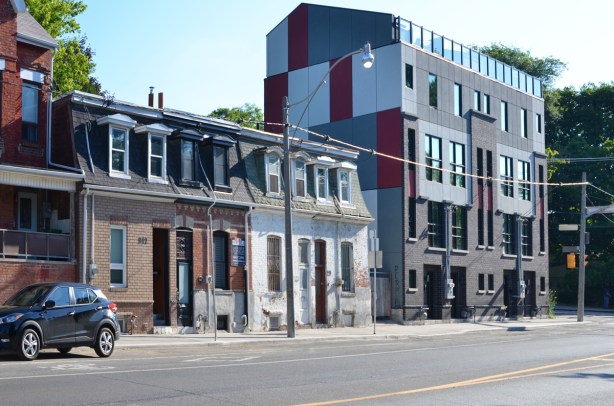 row houses, old mansard roof style from the 1800's with a new 4 storey apartment complex at the end