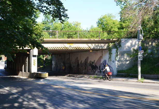 a cyclist on Dundas street about to go under the railway track bridge