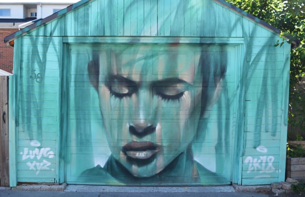 in blue tones, on a garage door, a portrait by luvsomone of a face with closed eyes