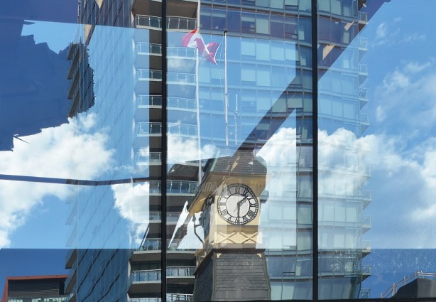 reflections of Yorkville clock tower in the glass condo across the street
