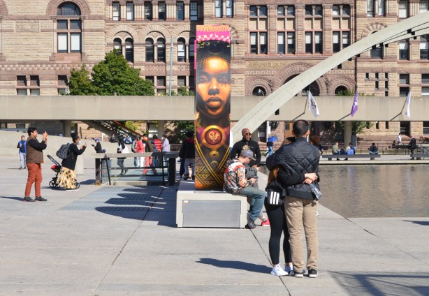 a couple hugs at the west end of the new 3 D toronto sign, with artwork by Danilo Deluxo McCallum on it 