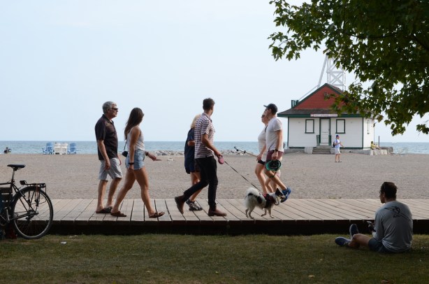 three couples on the boardwalk, one couple is walking their dog 