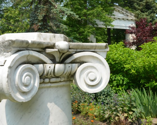 short white marble column in a garden