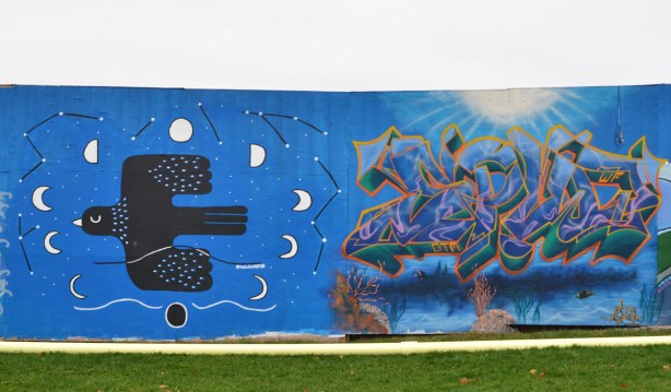 2 murals on hoardings, a stylized blackbird flying with the moon in different phases around it. on the right is a wildstyle