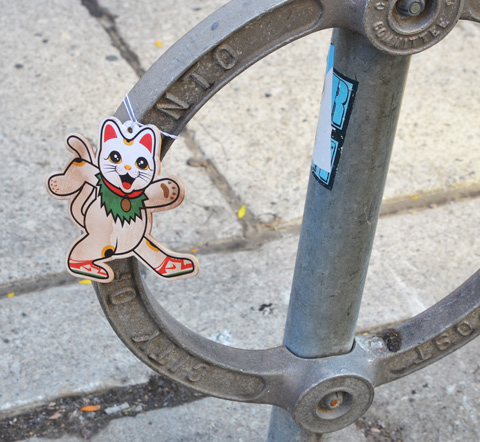 cat graffiti on cardboard, tied to Toronto circular bike stand