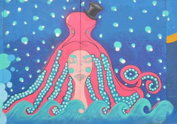 mural on hoardings, a woman with long braided turquoise hair under a pink octopus wearing a black top hat, mural by dbetty13, Desire Betty