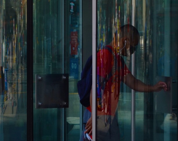 a man walks through a glass revolving door, reflections,