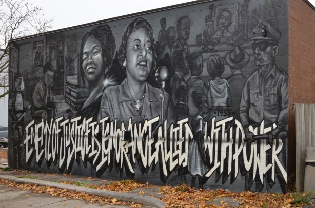 mural with words, Enemy of Justice is Ignorance allied with power. Black and white and grey