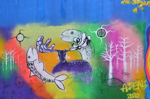 mural with two fish making a circle with a deer in betwee, some trees on both sides, multi coloured background