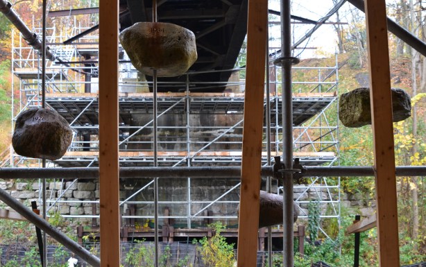 Artwork called High Water Mark, rocks at levels that match the flood levels of different years, on metal poles by a bridge beside the Don River 