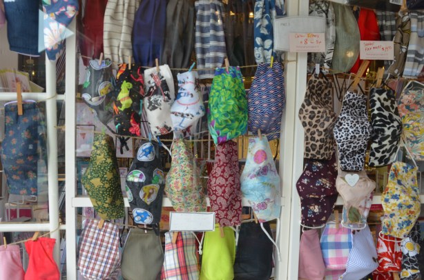 fabric covid masks for sale in the window of a store