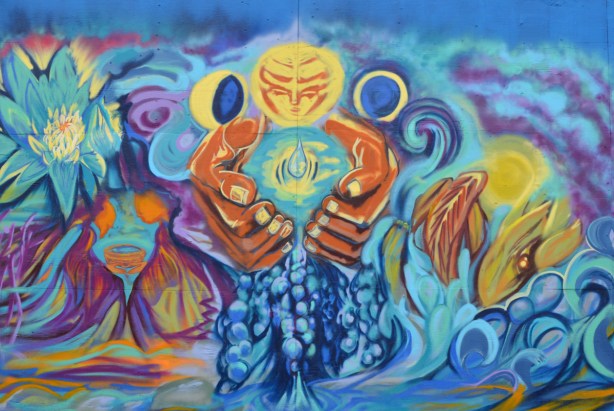 mural of large brown hands holding water