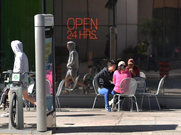 a group of young people sitting at a table outside an A & W restaurant 