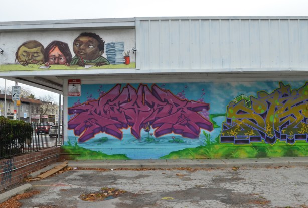 text street art in pink that looks like it is hovering over a pond