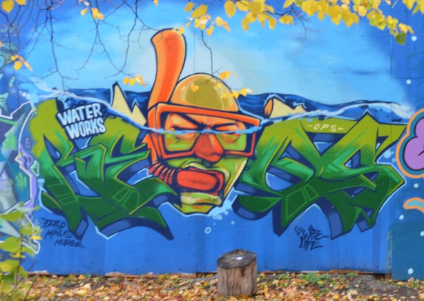 mural on hoardings near Ashbridge Bay water treatment facility, wallnoize project, head of bald man with diving mask and snorkel, in the water, 