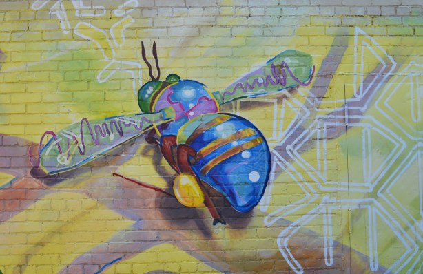 bee with blue body and bum in a mural