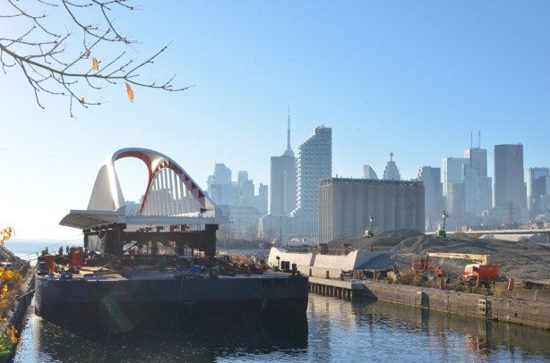 new Cherry street bridge on a barge in the Keating channel, just arrived from Nova Scotia, CN Tower and Toronto skyline in the distance