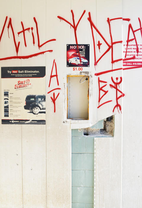 graffiti in red on the interior walls of an old abandoned and emptied car wash