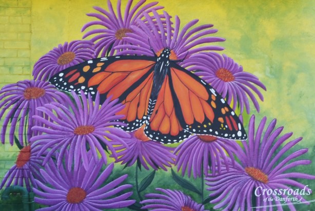from a mural, monarch butterfly in the middle of purple asters flowers