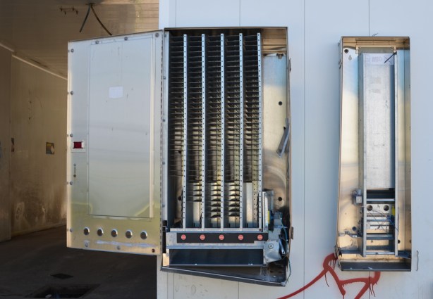 empty air freshener vending machine, metal, on a wall, with doors broken off 
