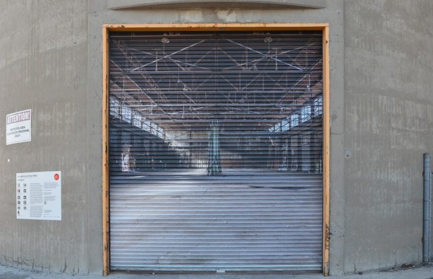 large photo of an empty old warehouse mounted on an exterior metal door 