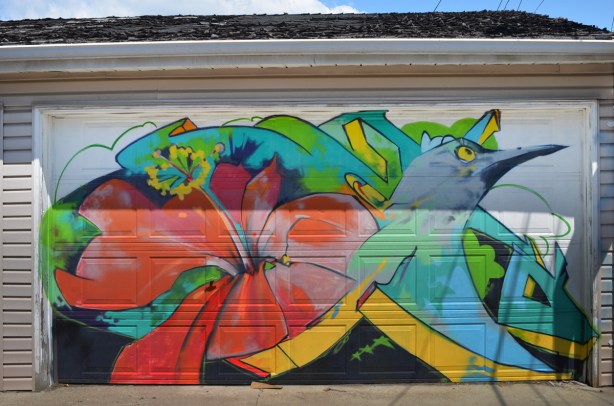 mural of a hummingbird with a red hibiscus flower