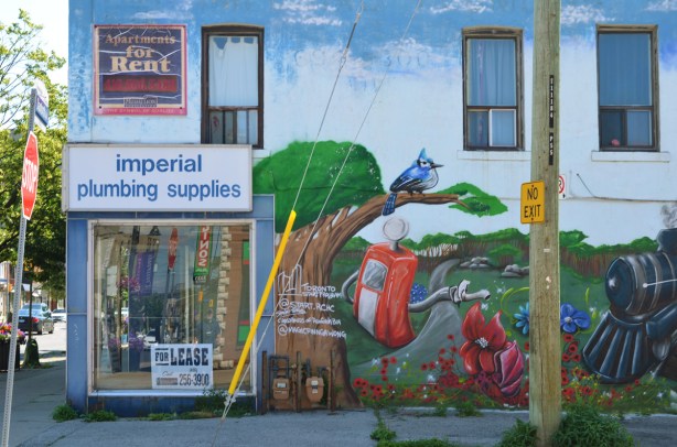on the side of a now empty Imperial Plumbing store is a mural by Basil Dwayne Jardine jr of a scene 