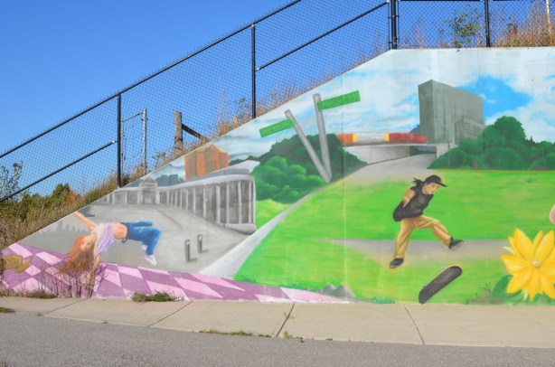 end of a mural underpass, sloped concrete with railing on top