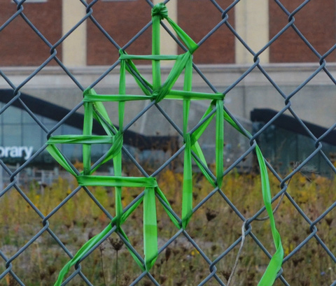 green ribbon woven into the chainlink fence between the West Toronto Railpath and MOCA, the Museum of Contemporary Art 