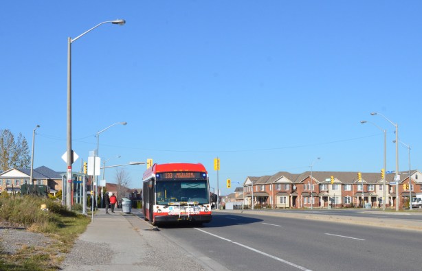 TTC bus parked on Finch just west of Morningside, route 133 Neilson. A row of houses in the background, on Morningside