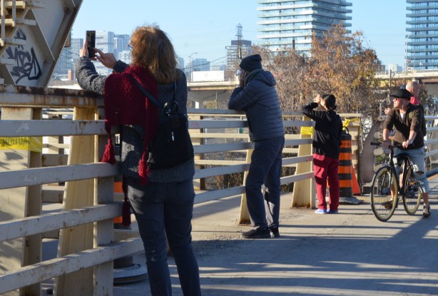 people standing on the cherry street bridge taking pictures of the new bridge 