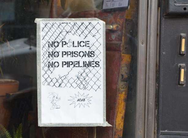 no police, no prisons, no pipeline, poster on a glass door